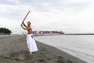 海岸で稽古をする男性　達人イメージ