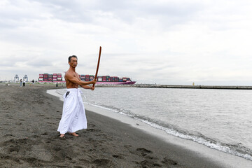 海岸で稽古をする男性　達人イメージ