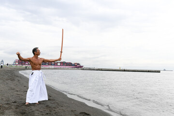 海岸で稽古をする男性　達人イメージ