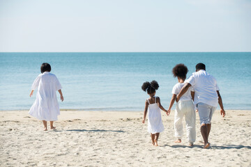 African Family With Two Children running on Beach on Summer Holiday.Parents with children enjoying vacation on beach.