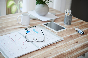 Opened folder with sales reports and glasses on table of entrepreneur