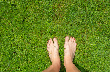 woman sitting barefoot on a lush green lawn. Smooth sexy female legs outdoors walking in the park. Varicose veins medicine concept.