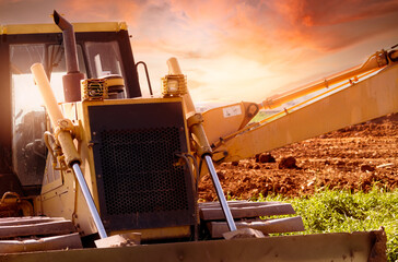 Selective focus on bulldozer on blur background of a backhoe at construction site. Excavation...
