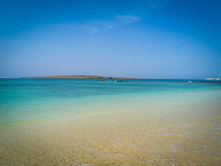 Calm ocean on Boa Vista Island, Cape Verde. Tropical climate, tranquil sea, clear blue sky and a perfect vacation. Selective focus on the horizon, blurred background.