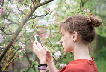 Young teenage girl in a blooming garden