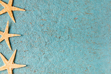 Fototapeta na wymiar Starfish on a blue textured background with copy space