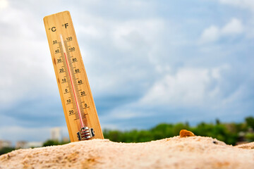 Weather thermometer in the sand against the sky showing a high ambient temperature - obrazy, fototapety, plakaty