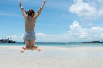 happy person jumping on the beach - obrazy, fototapety, plakaty