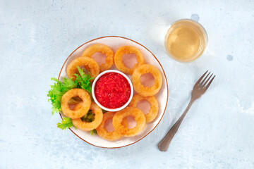 Calamari rings. Deep fried squid rings with a dip, salad, and a glass of wine, overhead flat lay shot