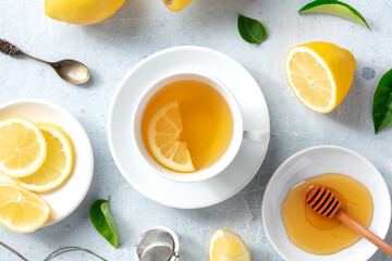 Lemon tea with honey, overhead flat lay shot. Organic lemons, green leaves and the natural remedy of the healthy beverage