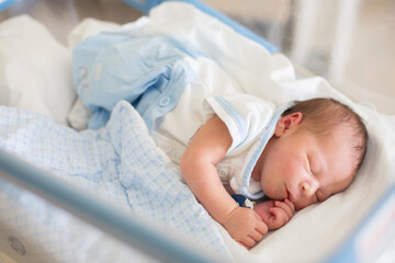 Newborn baby laying in crib in prenatal hospital