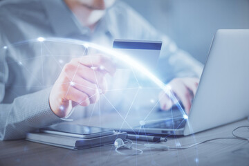 Double exposure of man hands holding a credit card and social network theme drawing. Digital finance and E-commerce concept.