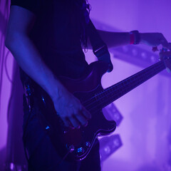 Obraz na płótnie Canvas A guitarist tunes electric bass guitar, close-up