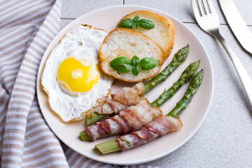 Toasted egg with asparagus and bacon on a plate. Delicious and healthy breakfast.