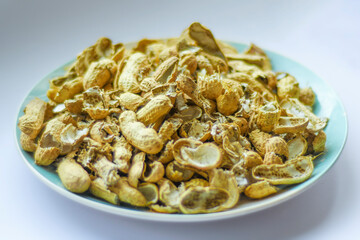 A pile of peanut shells in a plate. Closeup of leftover food in soft focus.