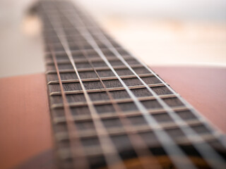 Acoustic classical guitar neck close-up, selective focus, bokeh, macro. Nylon guitar strings and frets.