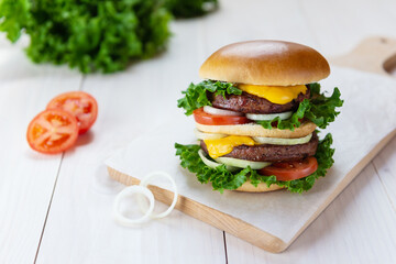 Vegan cheeseburger on a white wooden table.