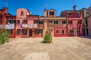 Old small beautiful multi colored houses (bright colors) in Burano island in a sunny spring day. Venetian lagoon, Venice, UNESCO world heritage site, Veneto, Italy, southern Europe.