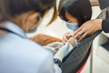 Coronavirus vaccination. Covid-19 vaccine. Doctor giving vaccinations to schoolchildren at School...