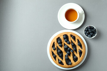 Concept of delicious breakfast with blueberry pie on gray background