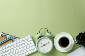 Workplace concept with alarm clock on green background