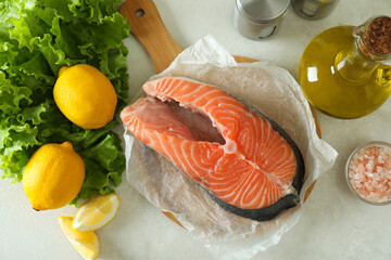 Concept of cooking salmon on white textured background