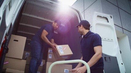 Bottom view of couriers unloading packages from a delivery truck. Shot with RED helium camera in 8K.