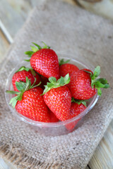 Fresh ripe strawberries in a plastic bowl. Large strawberries.