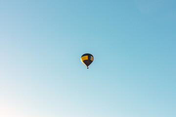 Hot Air Balloon on a blue sky.One Blue yellow hot air balloon in blue clear sky.Copy space.