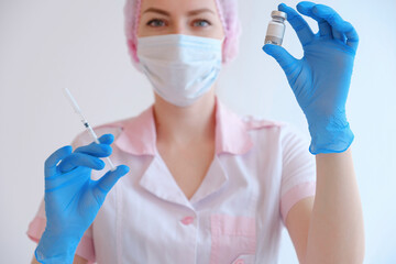 Female doctor holding syringe and COVID-19 vaccine. Healthcare And Medical concept.