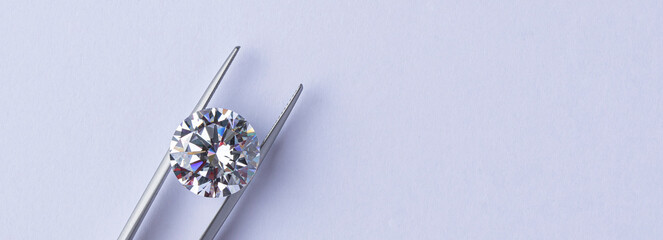 Polished diamonds of various sizes and shapes wit jewelry tools lie at the workplace of an expert examining the quality of stones on light background with copy space. High quality photo - obrazy, fototapety, plakaty