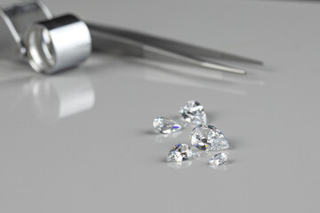 Polished diamonds of various sizes and shapes wit jewelry tools lie at the workplace of an expert...