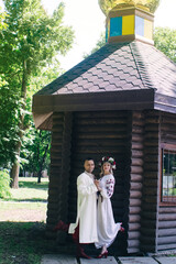 Fototapeta premium Young people dressed in vintage outfits to get married in the church. Reconstruction of Cossack customs in Ukraine. Old Slavic customs and traditional historical costumes. Stylized wedding