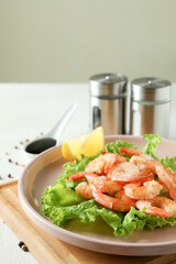 Plate of grilled shrimps on white textured table