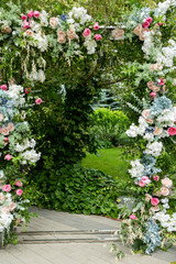 Fototapeta na wymiar Ceremony wedding arch decorations. Outdoor ceremony in the open air with bouquets of flowers.