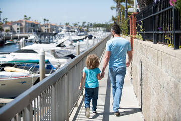 Father man and boy child promenade holding hands summer outdoors, family vacation © Olena