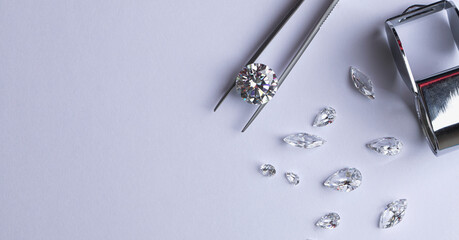 Polished diamonds of various sizes and shapes wit jewelry tools lie at the workplace of an expert...