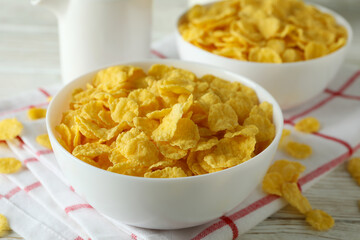 Concept of tasty breakfast with cornflakes on white wooden table
