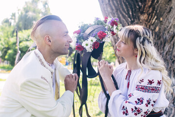 Young people are posing in traditional folk costumes. Cossacks man and woman in wreaths and...