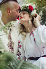 Young people are posing in traditional folk costumes. Cossacks man and woman in wreaths and...