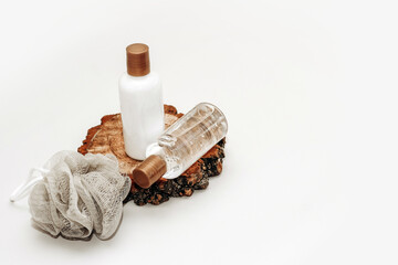 Cosmetic bottles for bathroom and washcloth on wooden background.