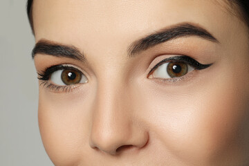 Naklejka premium Young woman with beautiful eyebrows on grey background, closeup