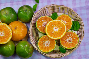 cut of half orange and tangerine isolate on a wooden table