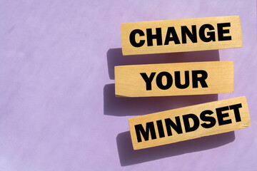 Wooden blocks form the text 'change your mindset' on beautiful pink background. Business concept.