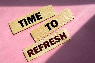 Time to refresh words on wooden blocks on pink background.