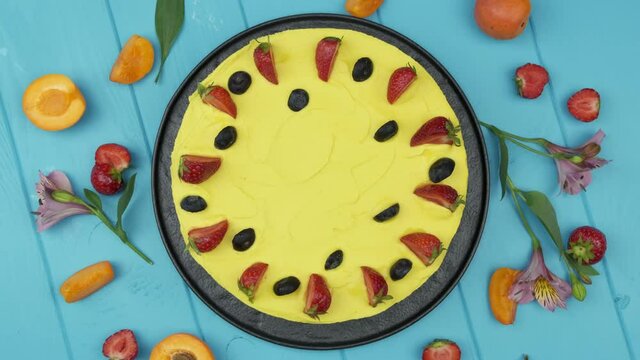 Sunny yellow cake. The custard is bright in color. Garnished with fresh berries. Strawberries, blueberries and more. blue background. Flat lay