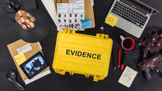 The FBI agent examines the criminal case, photographs and evidence. Top view