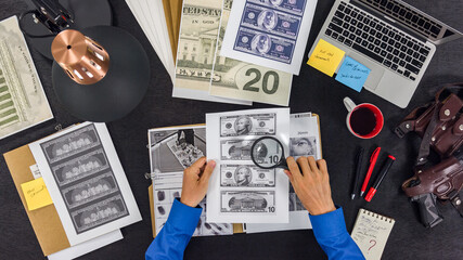Expert with magnifying glass checks suspicious money on the investigations desk