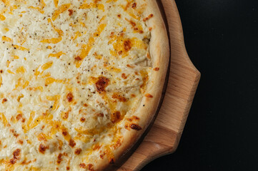 Delicious pizza Four Cheeses with cheddar, Parmesan, mozzarella and tomato sauce.