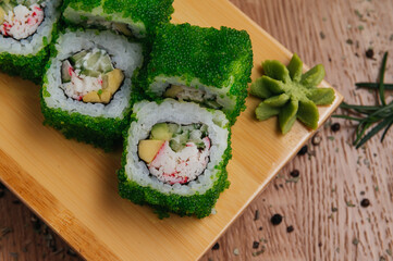 Sushi Rolls With Tobiko Green Caviar on wooden board